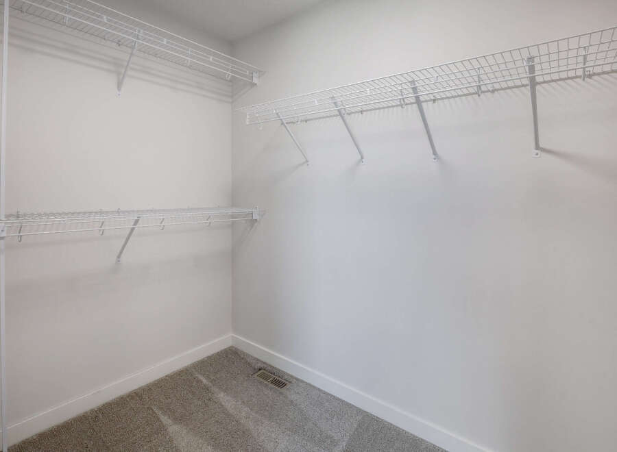 This spacious walk-in closet offers ample storage with its wire shelving system.