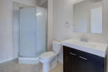 Step into this modern bathroom featuring a sleek glass shower enclosure and a stylish vanity with ample storage.
