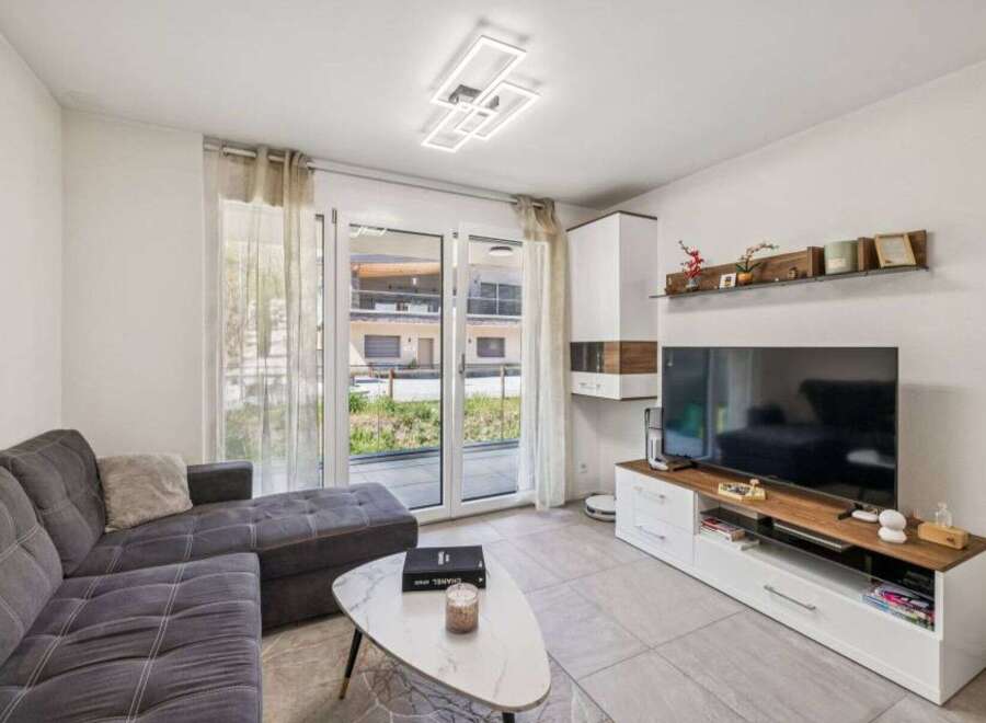 Discover modern living in this stylish property! Featuring a spacious living room with a comfortable sofa and a sleek coffee table, perfect for relaxation.