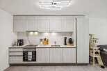 This modern kitchen boasts sleek, light-colored cabinetry and a stylish marble backsplash.