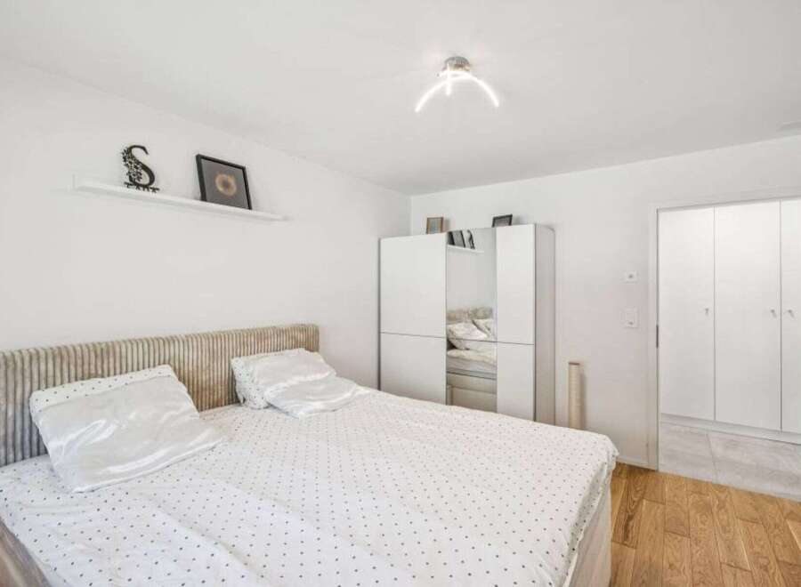 This bright and airy bedroom offers a serene retreat with its minimalist design and ample natural light.