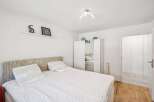 This bright and airy bedroom offers a serene retreat with its minimalist design and ample natural light.