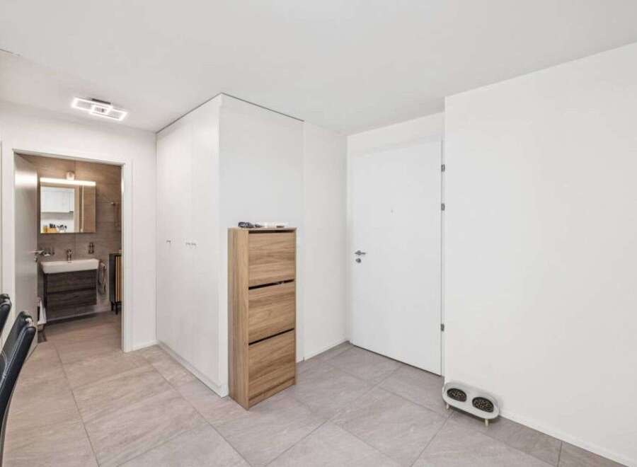 Step into this modern and stylish entryway, featuring sleek tile flooring and ample storage solutions.