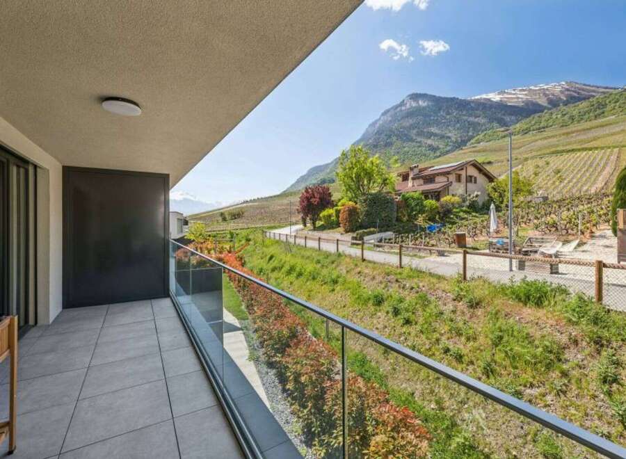 Enjoy breathtaking views from this stunning property! This home features a spacious balcony with glass railings, perfect for taking in the surrounding landscape.