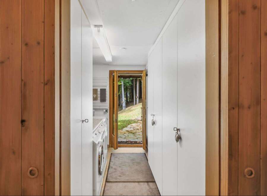 Step into a world of tranquility with this stunning property, featuring a bright and airy hallway that leads to a serene outdoor view.