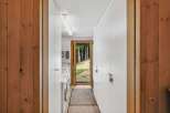 Step into a world of tranquility with this stunning property, featuring a bright and airy hallway that leads to a serene outdoor view.