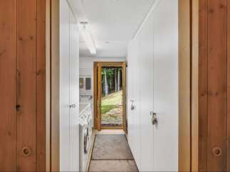 Step into a world of tranquility with this stunning property, featuring a bright and airy hallway that leads to a serene outdoor view.