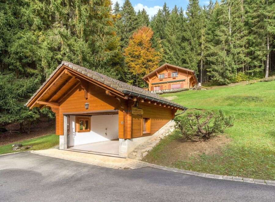 Nestled in a serene, wooded setting, this charming property boasts a beautiful wooden garage and a cozy cabin-style home.