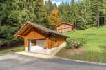 Nestled in a serene, wooded setting, this charming property boasts a beautiful wooden garage and a cozy cabin-style home.
