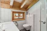 This charming bathroom features a unique wooden ceiling and a small window that allows natural light to flood the space.