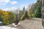 Enjoy breathtaking views from this stunning property featuring a spacious wooden deck, perfect for outdoor gatherings.