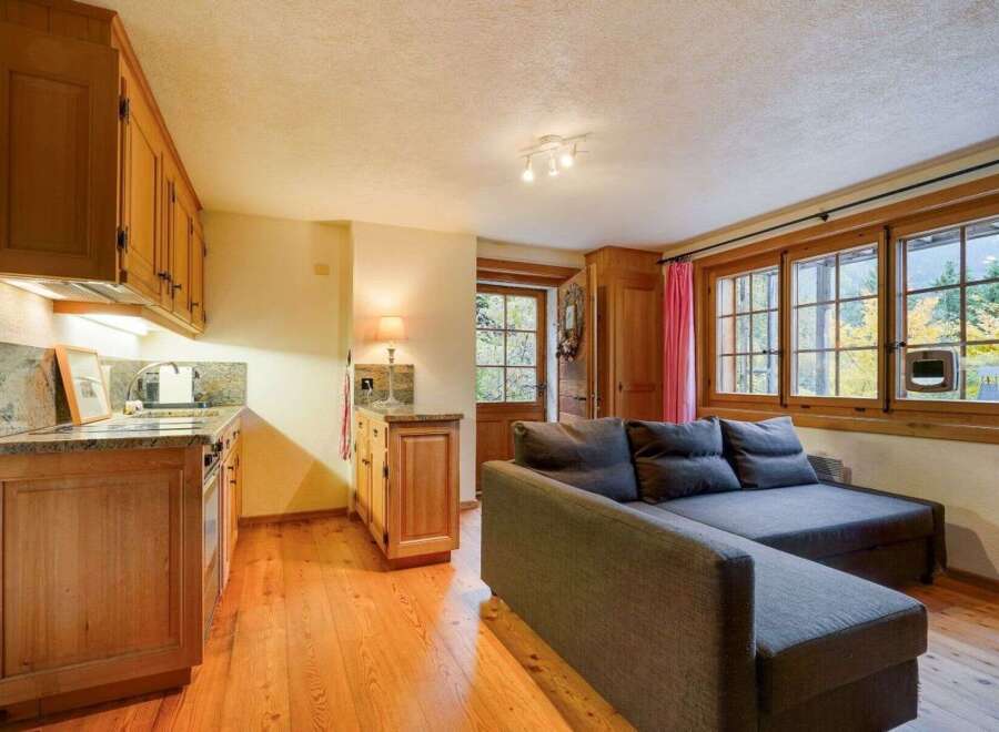 Discover the charm of this cozy property, featuring a well-equipped kitchen with wooden cabinetry and a stylish countertop.