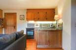 This charming kitchen features warm wooden cabinetry and a granite countertop, creating a cozy and inviting atmosphere.