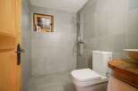 This charming bathroom features a cozy, rustic design with a wooden door and window frame.