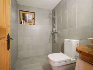 This charming bathroom features a cozy, rustic design with a wooden door and window frame.
