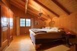 Step into a cozy bedroom retreat with warm wooden accents and a charming ambiance.