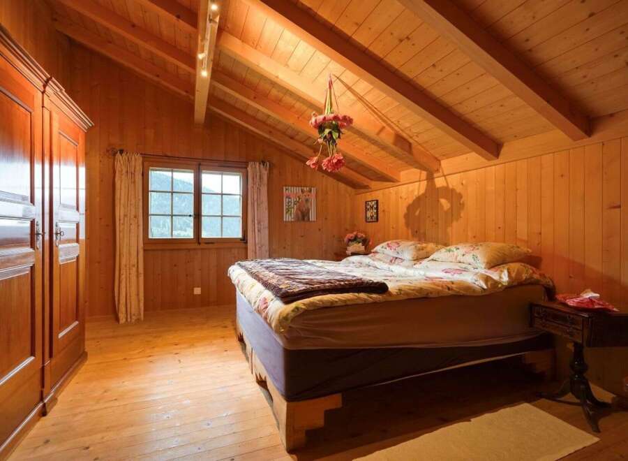 Step into a cozy bedroom retreat with warm wooden accents and a charming ambiance.