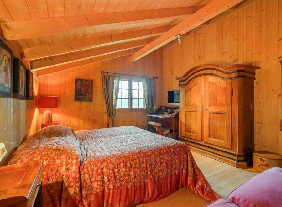 Step into a cozy bedroom retreat with warm wooden accents and a charming ambiance.