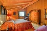 Step into a cozy bedroom retreat with warm wooden accents and a charming ambiance.