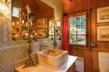 Step into a rustic bathroom retreat, where natural wood paneling and a unique stone sink create a warm and inviting atmosphere.