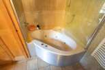 Indulge in luxury with this stunning bathroom featuring a modern corner jacuzzi tub.