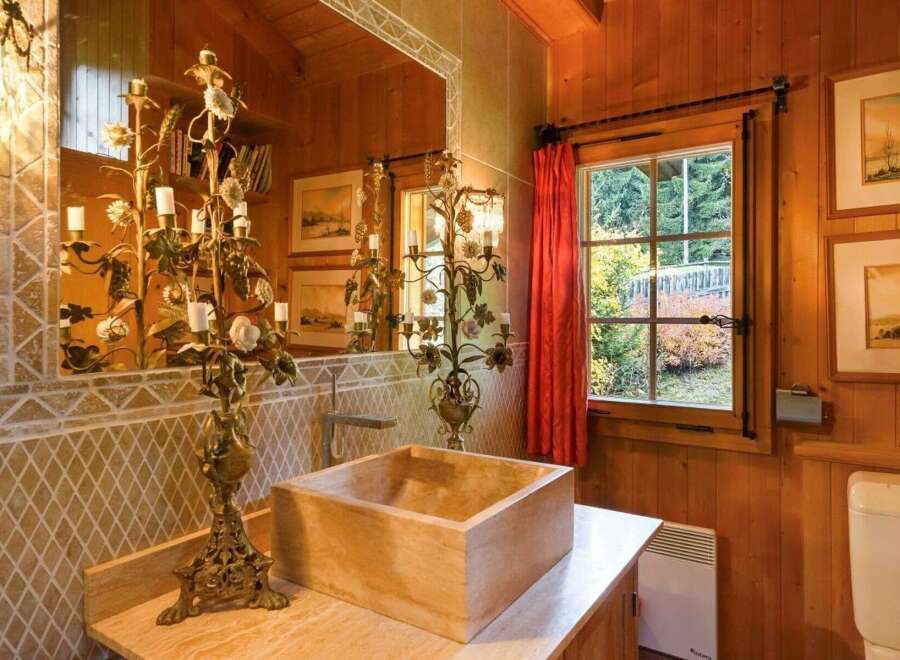 Step into a rustic bathroom retreat, where natural wood paneling and a unique stone sink create a warm and inviting atmosphere.