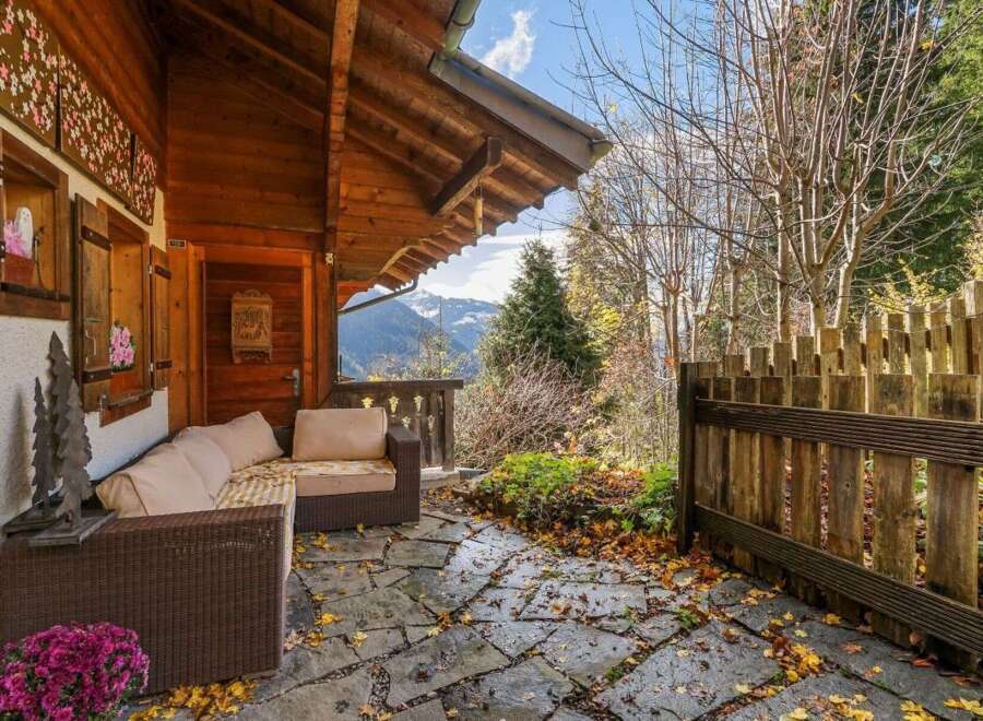 Escape to the mountains with this charming chalet, featuring a cozy outdoor seating area perfect for enjoying the stunning views.