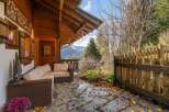 Escape to the mountains with this charming chalet, featuring a cozy outdoor seating area perfect for enjoying the stunning views.