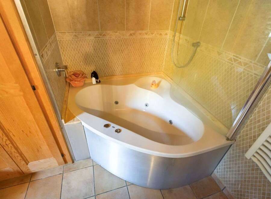 Indulge in luxury with this stunning bathroom featuring a modern corner jacuzzi tub.