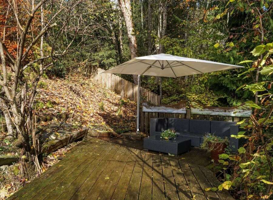 Enjoy the tranquility of this outdoor oasis! This property features a beautiful wooden deck, perfect for relaxing or entertaining.