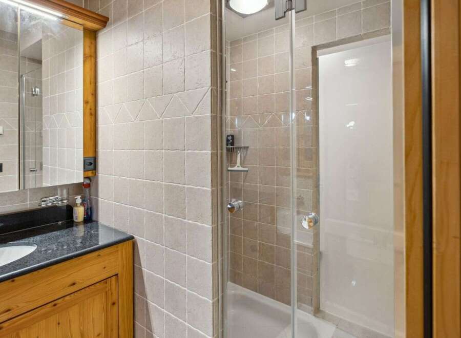 Step into this beautifully designed bathroom featuring a modern glass shower enclosure.