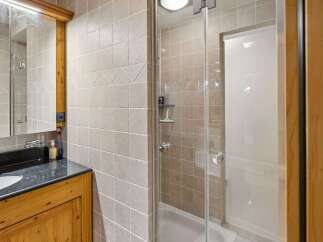 Step into this beautifully designed bathroom featuring a modern glass shower enclosure.