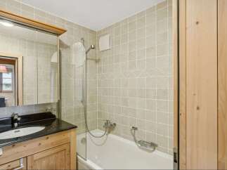 This charming bathroom features a combination of natural wood and neutral tones, creating a warm and inviting atmosphere.