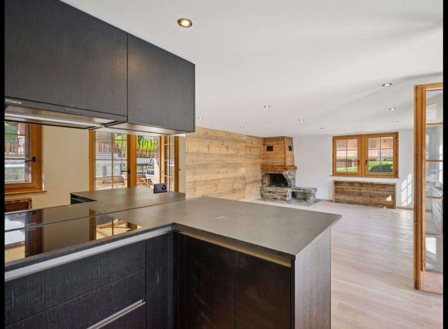 Discover the epitome of modern living in this stunning property, featuring a sleek kitchen with dark cabinetry and a contemporary countertop.