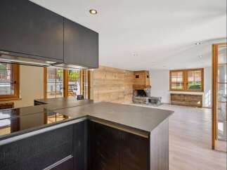 Discover the epitome of modern living in this stunning property, featuring a sleek kitchen with dark cabinetry and a contemporary countertop.