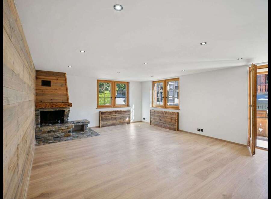 Step into this inviting living space, featuring a stunning wooden fireplace and elegant wooden floors.
