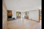 Step into this inviting living space, featuring a stunning wooden fireplace and elegant wooden floors.