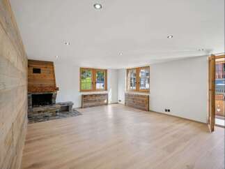 Step into this inviting living space, featuring a stunning wooden fireplace and elegant wooden floors.
