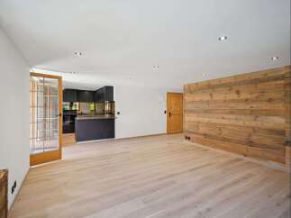Discover the charm of this stunning property, featuring a modern kitchen and a warm, inviting wooden accent wall.