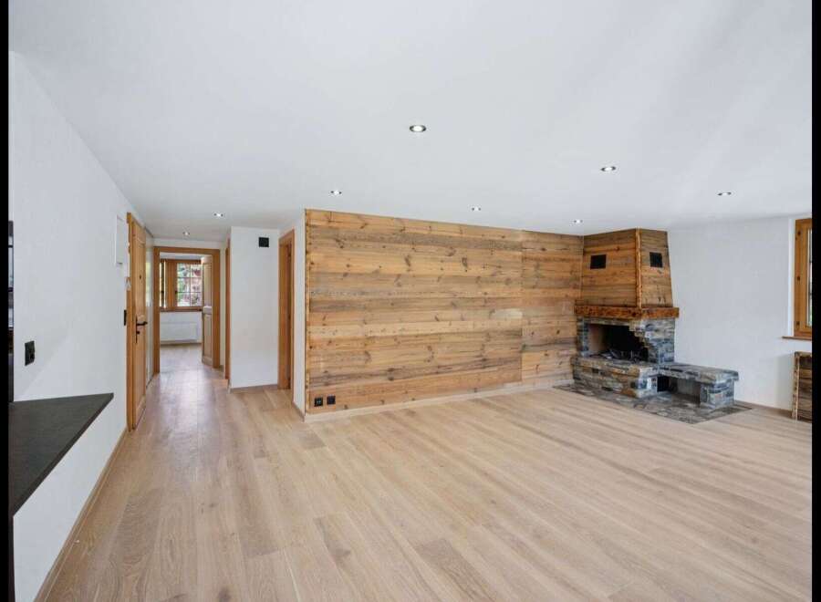 This stunning property boasts a warm and inviting interior, featuring a beautiful wooden accent wall and a cozy fireplace.