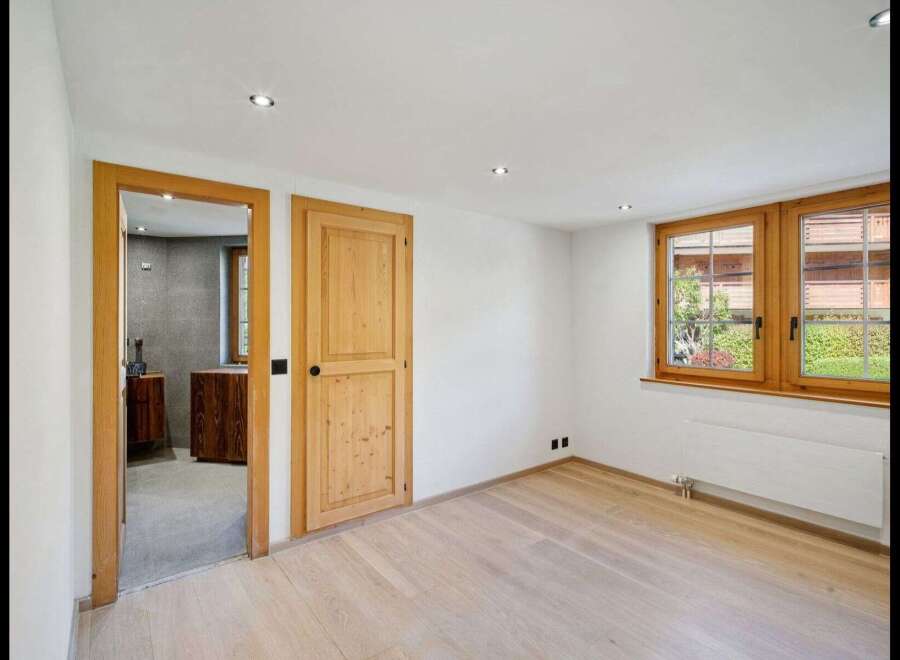 Discover the charm of this inviting room, featuring warm wooden doors and a bright, airy ambiance.