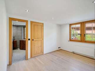 Discover the charm of this inviting room, featuring warm wooden doors and a bright, airy ambiance.