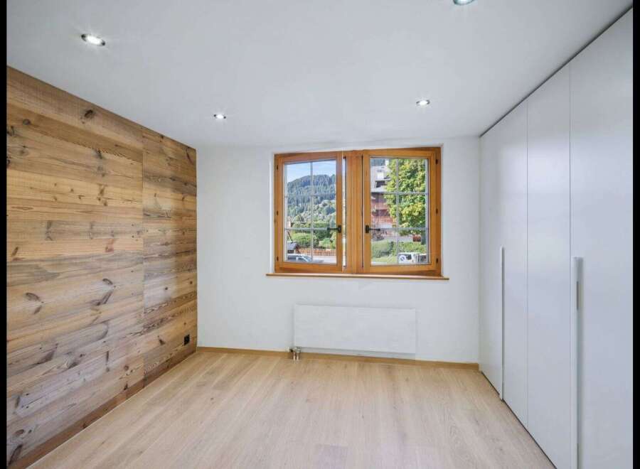 This stunning property boasts a warm and inviting interior, featuring a beautiful wooden accent wall that adds character and charm.