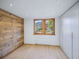 This stunning property boasts a warm and inviting interior, featuring a beautiful wooden accent wall that adds character and charm.