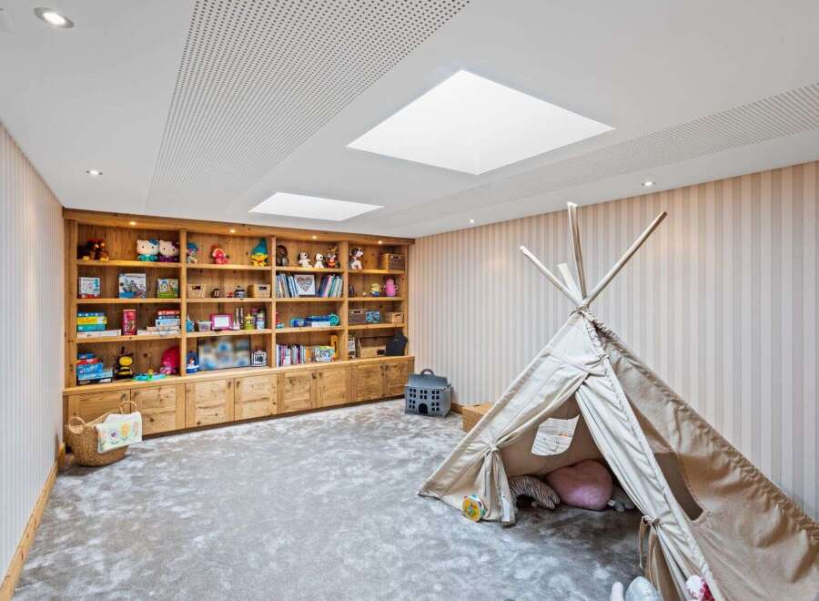 This charming playroom features a custom-built wooden bookshelf, perfect for storing toys and books.