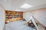 This charming playroom features a custom-built wooden bookshelf, perfect for storing toys and books.