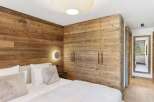 Experience rustic elegance in this stunning bedroom featuring exquisite wood paneling and a modern design.