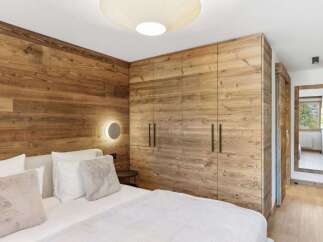 Experience rustic elegance in this stunning bedroom featuring exquisite wood paneling and a modern design.