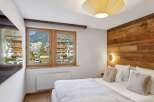 Experience the charm of this cozy bedroom, featuring a stunning wooden accent wall and a bright, airy ambiance.