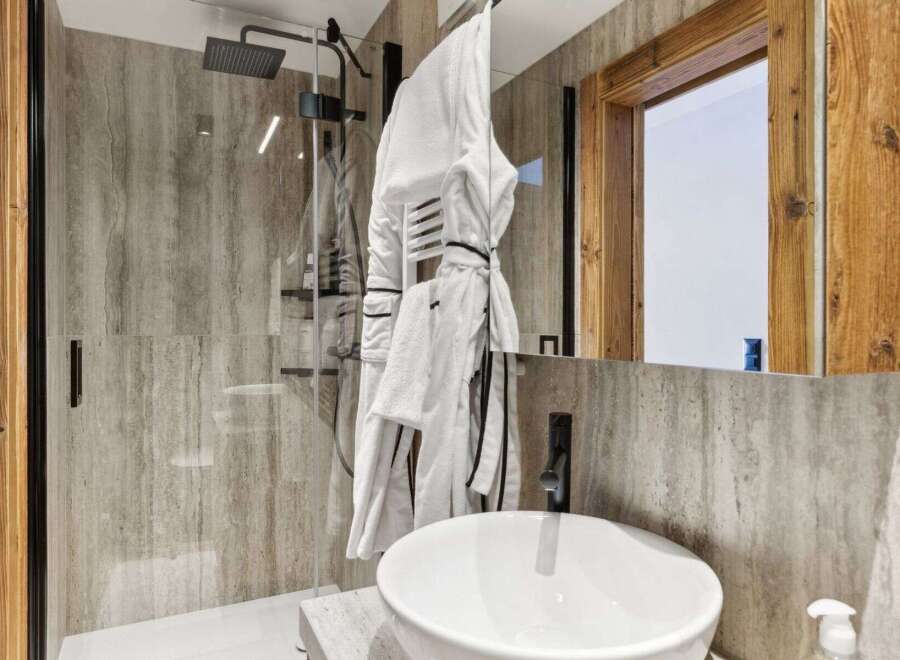 Step into luxury with this stunning bathroom featuring a sleek glass shower and a modern sink.